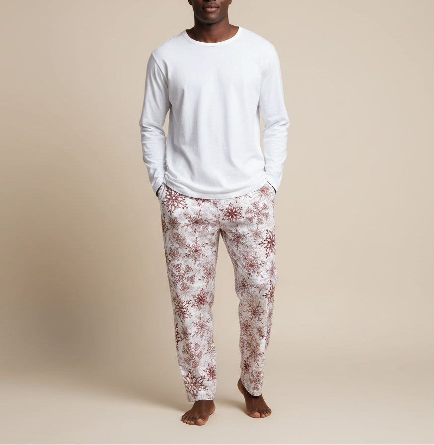 Man wearing a white long-sleeve shirt and floral pajama pants on a beige background