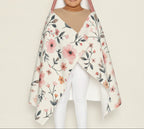 Person wearing a floral cape over a plain background