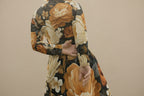 Close-up of a person wearing a floral-patterned garment with orange, white, and black colors.