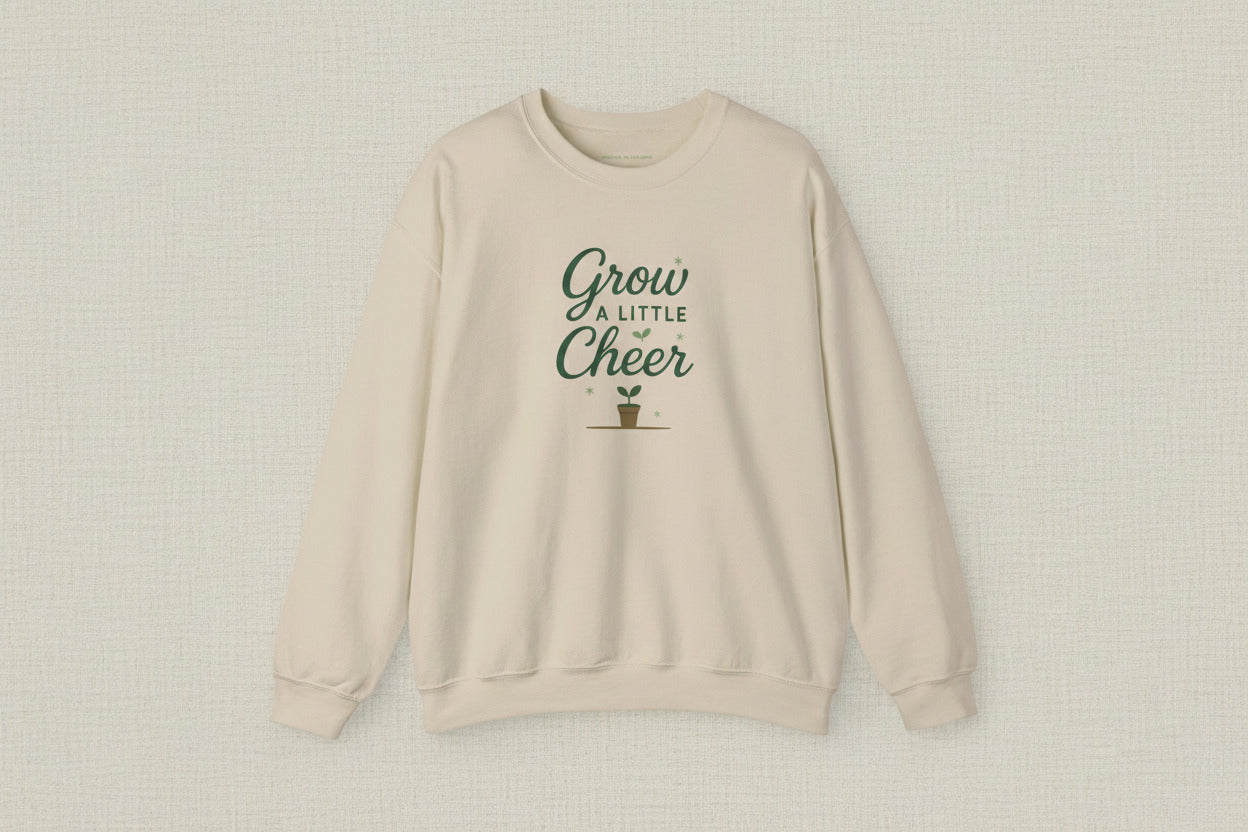 Beige sweatshirt with 'Grow a Little Cheer' text and plant icon on a white background