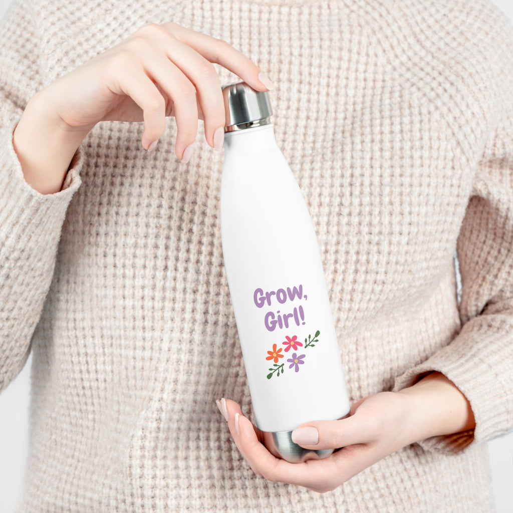 Person holding a white water bottle with 'Grow, Girl!' text and floral design.