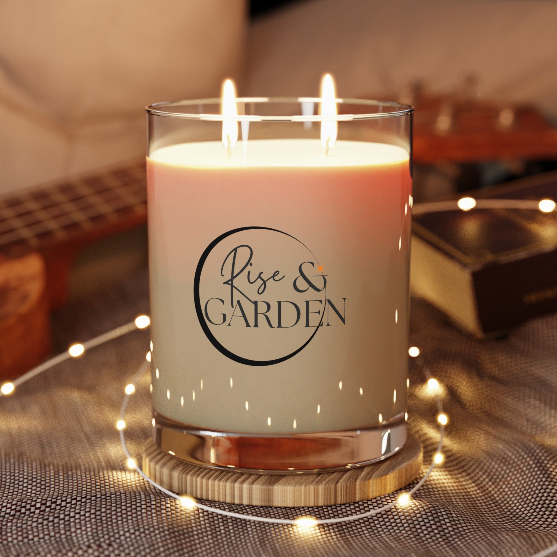 Candle with 'Rise & Garden' label on a decorative surface with lights