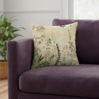 Floral-patterned pillow on a purple sofa with a plant in the background