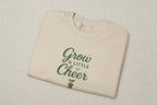 Beige t-shirt with 'Grow a Little Cheer' text on a white background