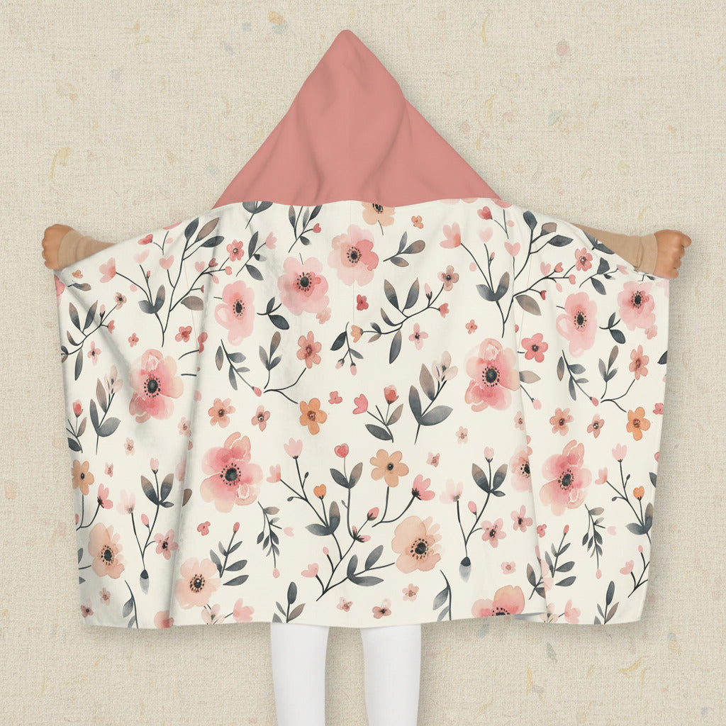 Floral patterned hooded blanket with pink hood on a neutral background