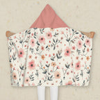Floral patterned hooded blanket with pink hood on a neutral background