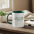 White mug with green interior and handle, featuring text on a beige background