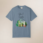 Blue t-shirt with 'Rise & Garden' design on a beige background