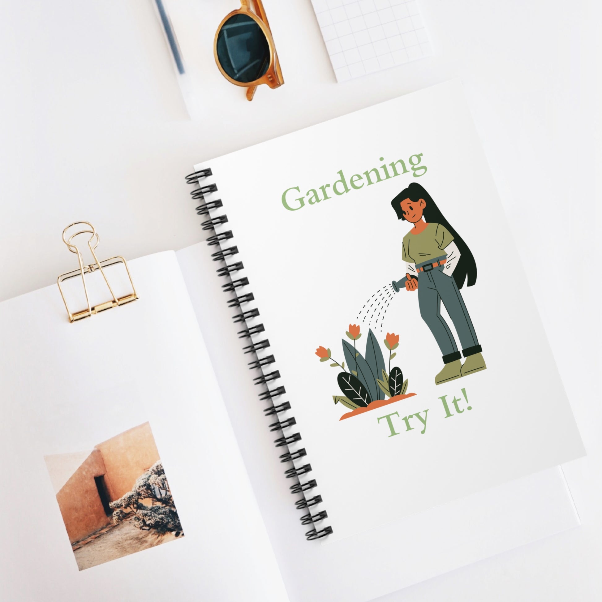 Notebook with gardening-themed illustration and text on a white surface