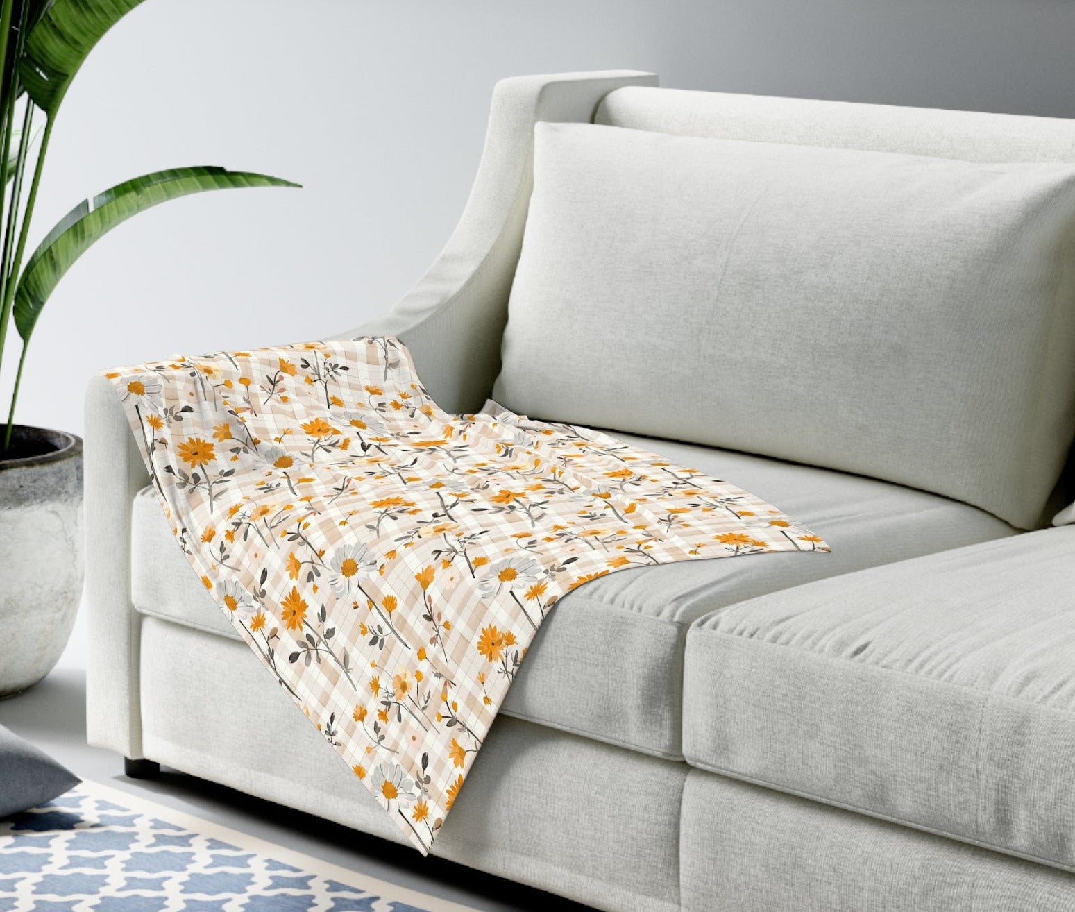 Gray sofa with a colorful blanket featuring cartoon characters in a living room setting.
