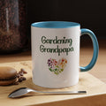 Mug with 'Gardening Grandpapa' text and heart design on a wooden surface with coffee beans and a spoon.