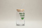 Clear glass tumbler with bamboo lid and straw, featuring 'Wake Up Garden' text and leaf design on a white background.