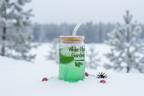 Green drink in a mason jar with a straw against a snowy background