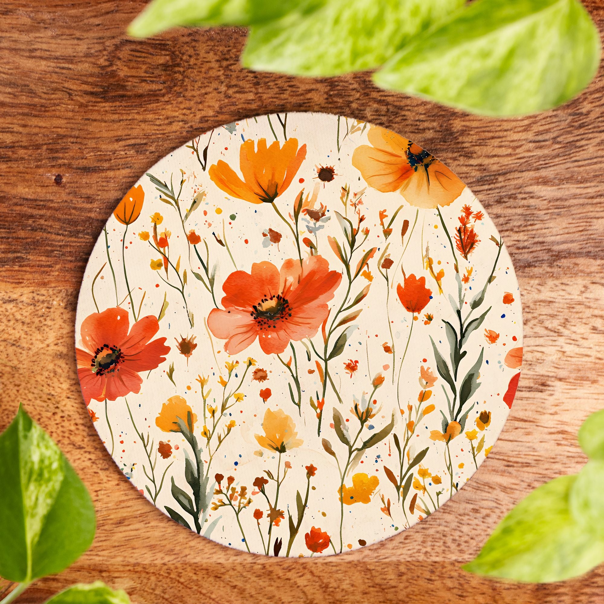 Round floral coaster with orange and red flowers on a wooden surface