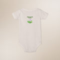 White baby onesie with 'New to the Patch' text and design on a beige background