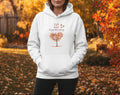 White hoodie with a tree graphic and text on a beige background