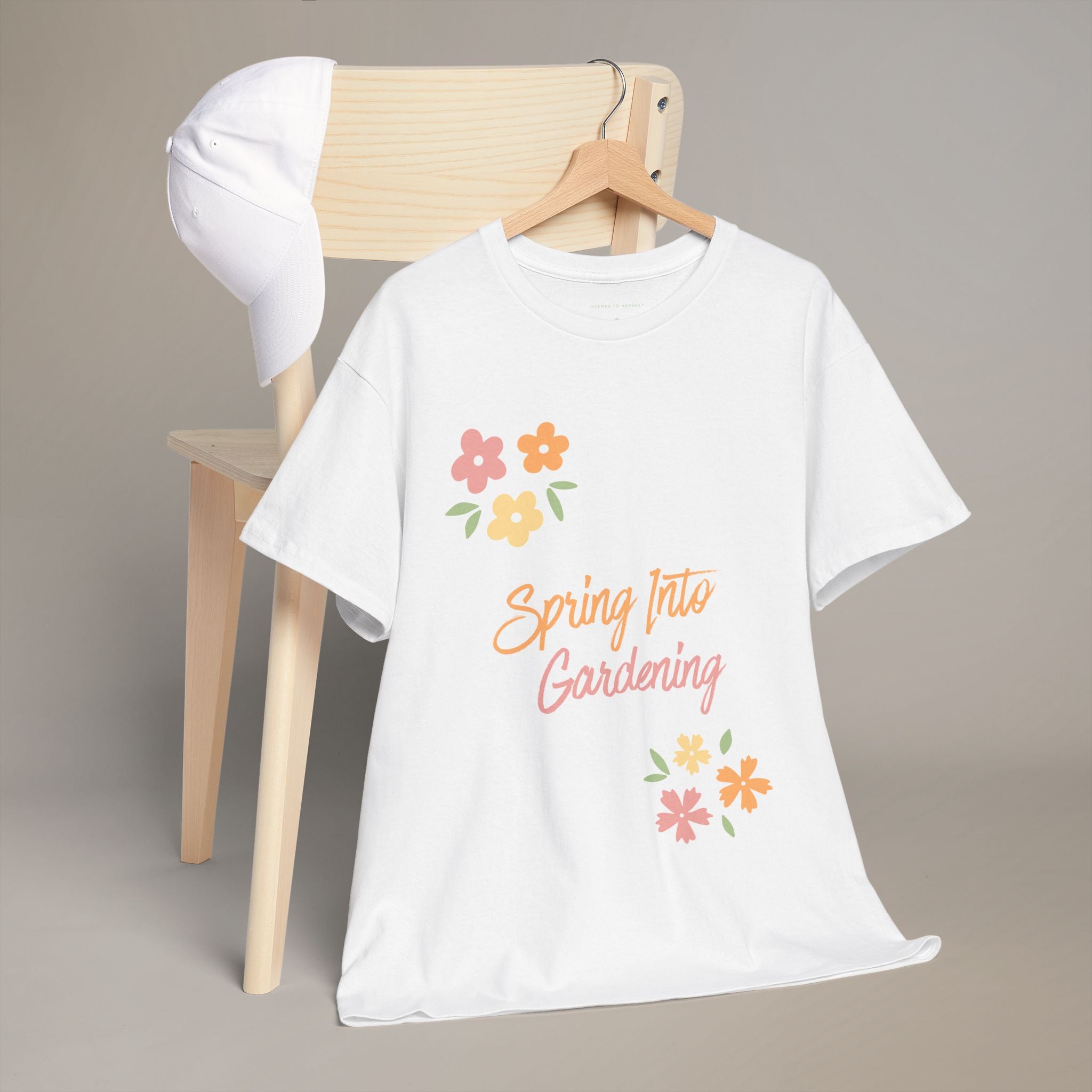 White t-shirt with 'Spring Into Gardening' text and flowers on a wooden chair.