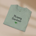 Folded green t-shirt with 'Mommy Gardener' text on a beige background