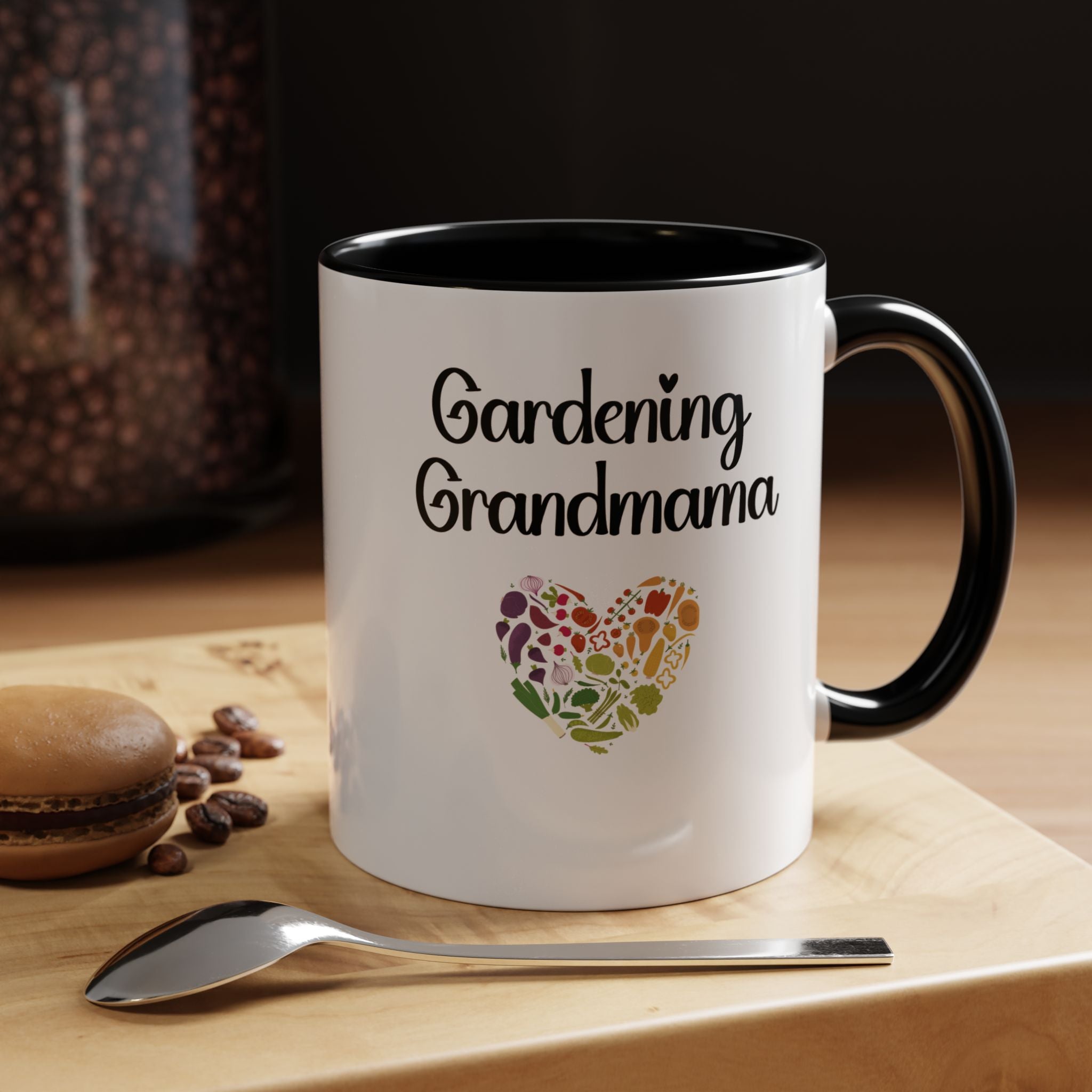 White mug with 'Gardening Grandma' text and heart design on a wooden surface with coffee beans and a spoon.