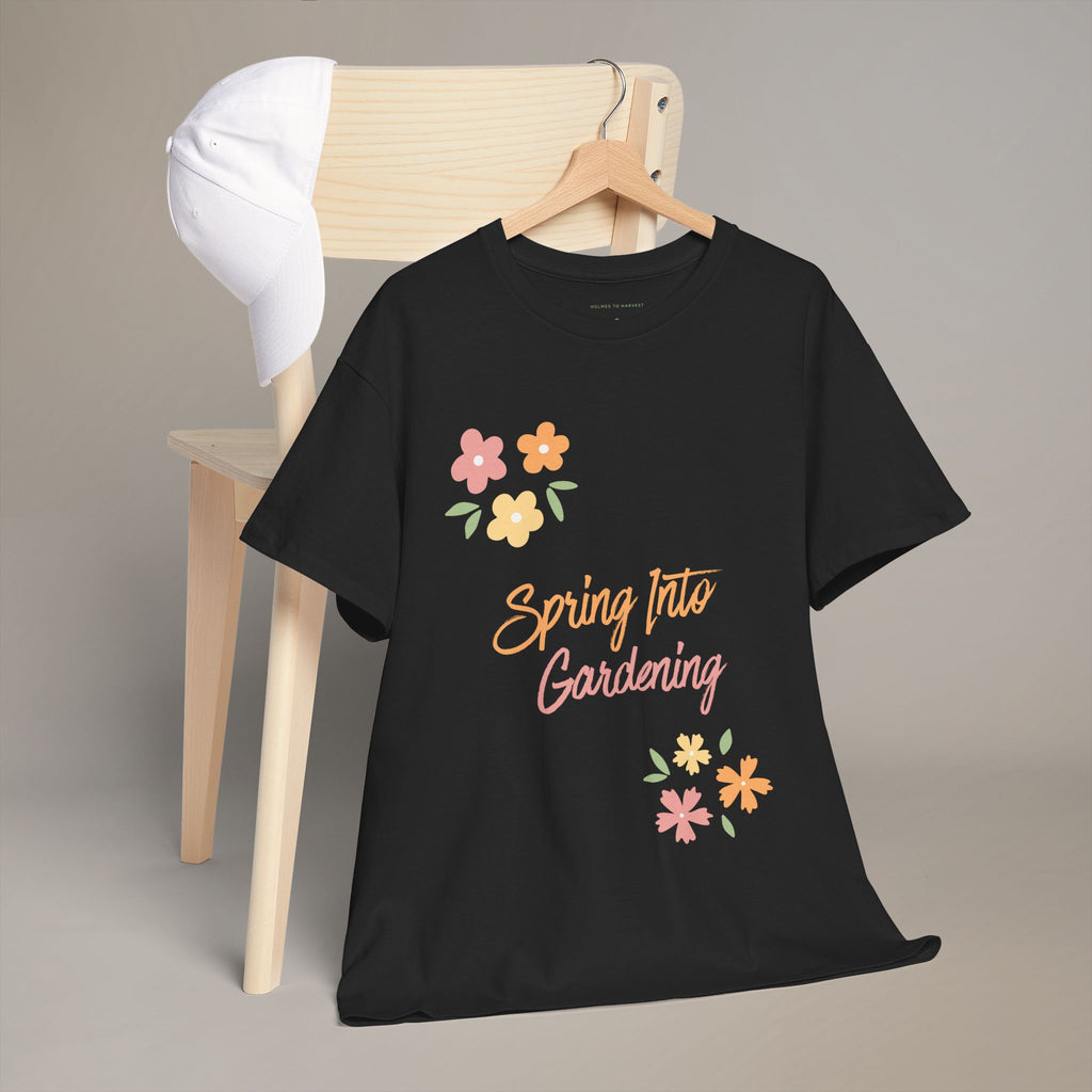 Black t-shirt with 'Spring Into Gardening' text and floral designs on a wooden chair.