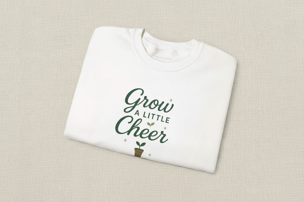 White sweatshirt with 'Grow a Little Cheer' text on a white background