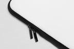 Close-up of a black zipper on a white surface