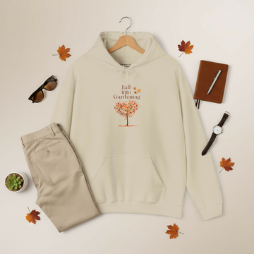 Beige hoodie with 'Fall into Gardening' design, pants, sunglasses, notebook, and watch on a light background.