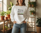 Woman wearing a 'Mommy Gardener' sweatshirt in a home setting with plants.