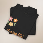 Black t-shirt with colorful floral design and 'Spring Into' text on a beige background
