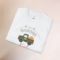 White t-shirt with a graphic of a green truck carrying pumpkins and the word 'Garden' on a beige background.