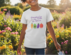 Child wearing a t-shirt with 'Gardening is My Time to Shine' and vegetable graphics in a garden setting.
