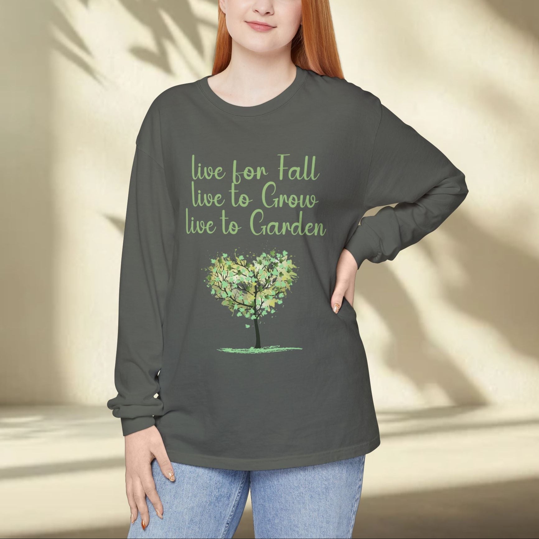 Person wearing a dark gray long-sleeve shirt with a tree graphic and text, standing against a neutral background.