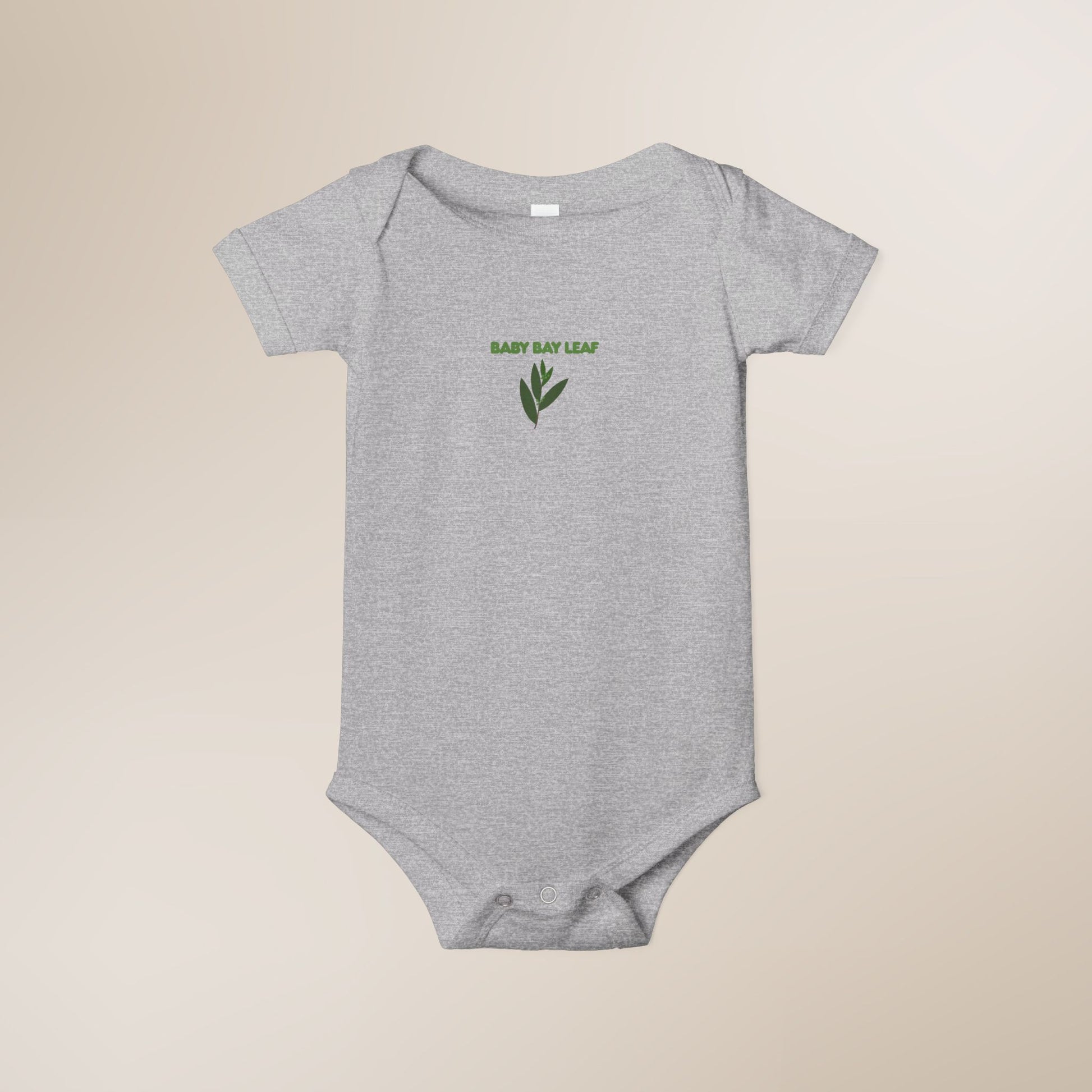 Gray baby onesie with 'Baby Bay Leaf' text and leaf design on a beige background