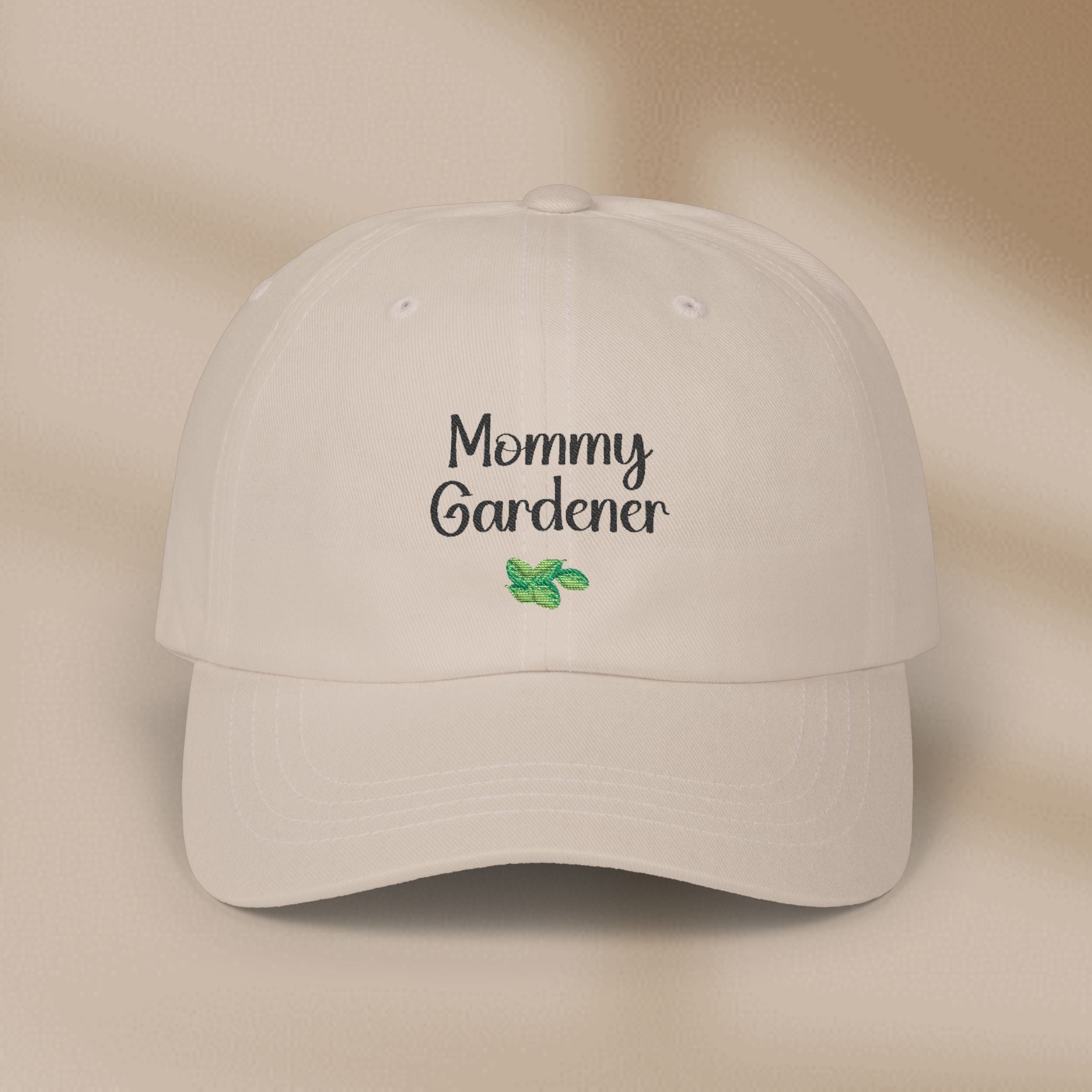Beige cap with 'Mommy Gardener' text and leaf design on a beige background