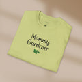 Folded light green t-shirt with 'Mommy Gardener' text on a beige background