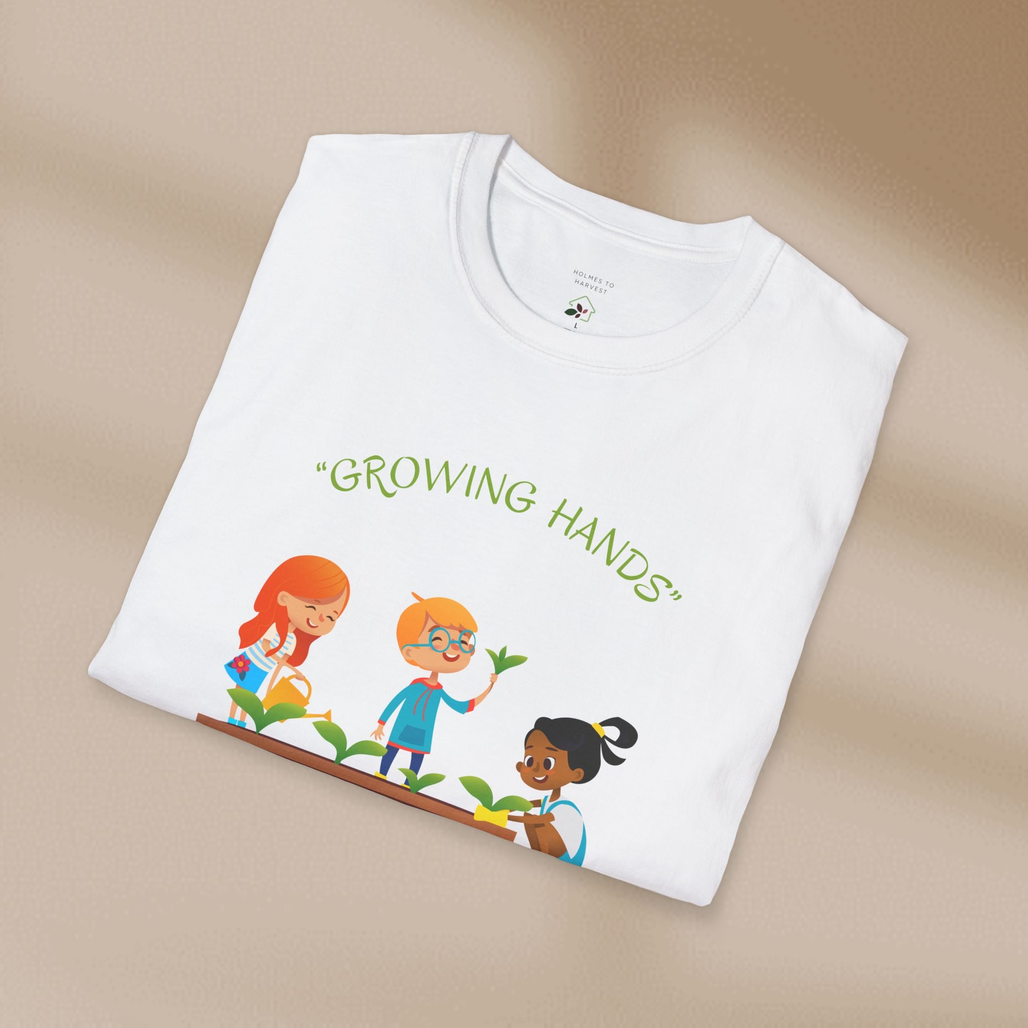 Folded white t-shirt with 'Growing Hands' illustration on a beige background