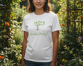 Person wearing a white t-shirt with 'Garden Strong' design in a garden setting