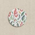 Round coaster with a colorful leaf pattern on a white background
