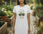 Person wearing a white t-shirt with a garden-themed design in a garden setting