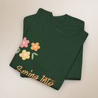 Black t-shirt with colorful floral design and 'Spring Into' text on a beige background