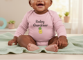 Pink baby onesie with 'Baby Gardener' and a pineapple graphic on a white background