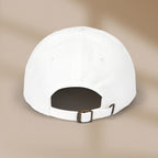 White cap with a brown buckle on a beige background