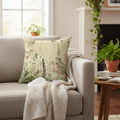 Decorative pillow with floral pattern on a gray sofa in a living room.