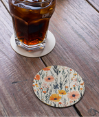 Glass of iced drink with a floral coaster on a wooden surface