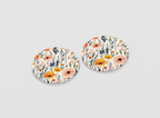 Pair of floral round coasters on a light gray background