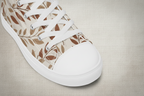 Sneaker with leaf pattern and white laces on a white background