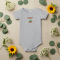 Gray baby onesie with 'New to the Patch' text and graphics on a beige background
