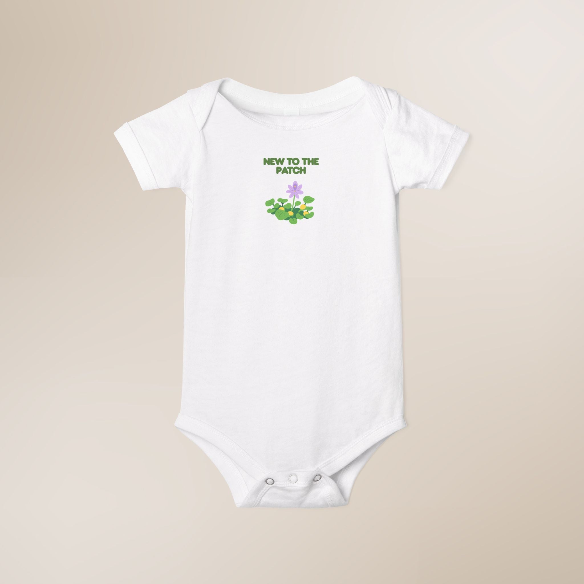 White baby onesie with 'New to the Patch' text and graphic on a beige background