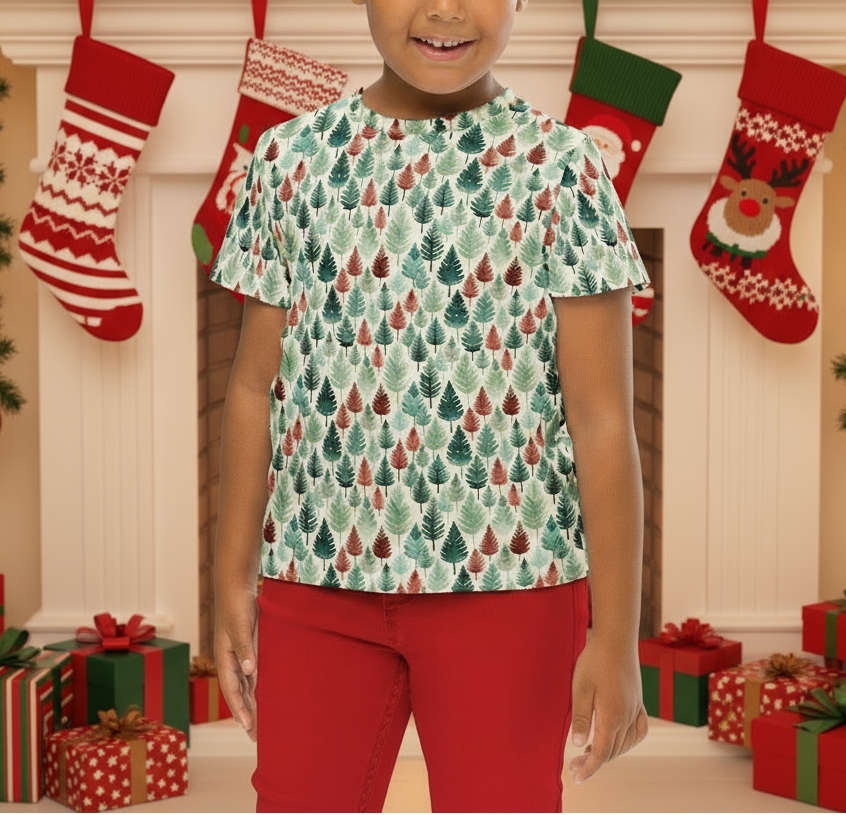 Child wearing a Christmas-themed shirt in front of a decorated fireplace with stockings and presents.
