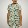 Child wearing a green pajama set with tree pattern on a white background